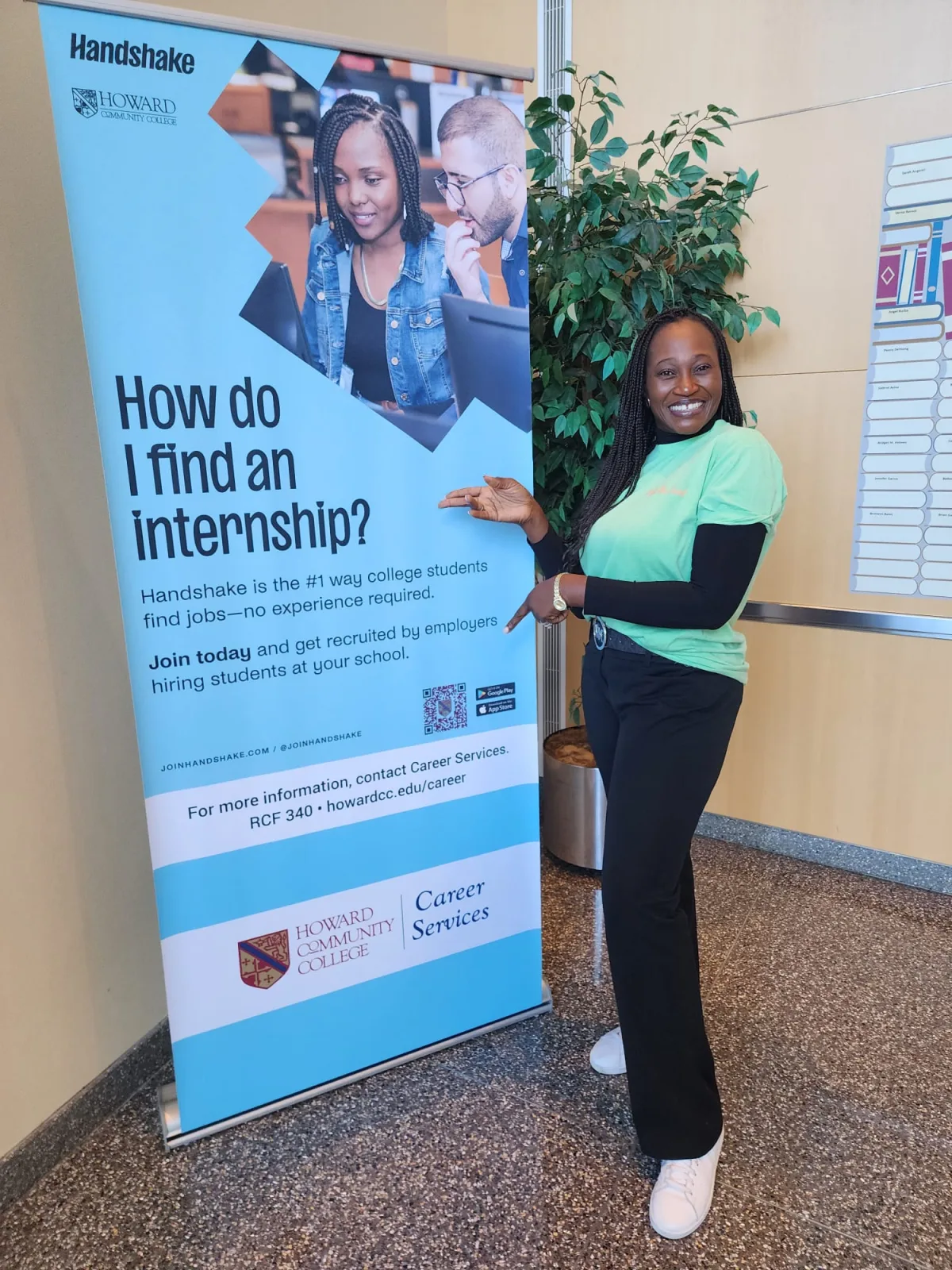 R1YC representative standing beside an internship information banner at the job fair
